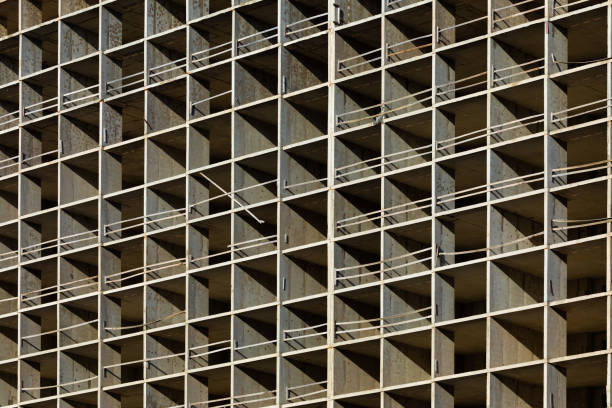 istock The light or bright grey background or backdrop of new concrete building construction in the rays of midday sun with many lines, squares, rhombs,triangles and rectangles 1327459085