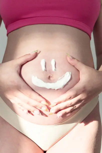 Fanny face on pregnant women stomach. Concept of a happy family