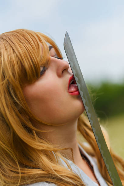 Asian woman lick her katana sword. Fighting and sensitive concept.