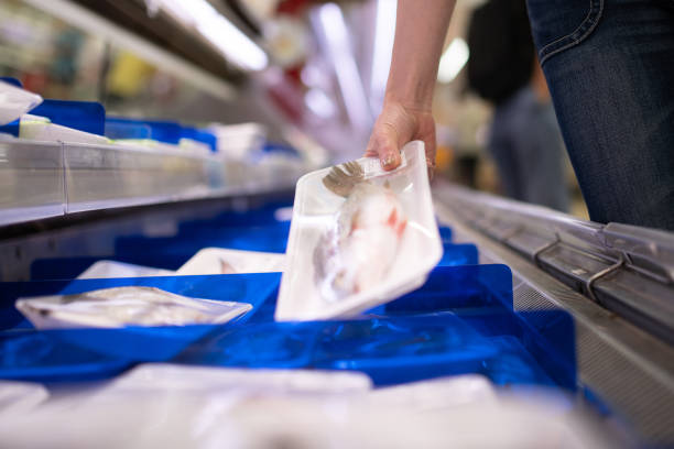 Female hand picking up a fish in a supermarket