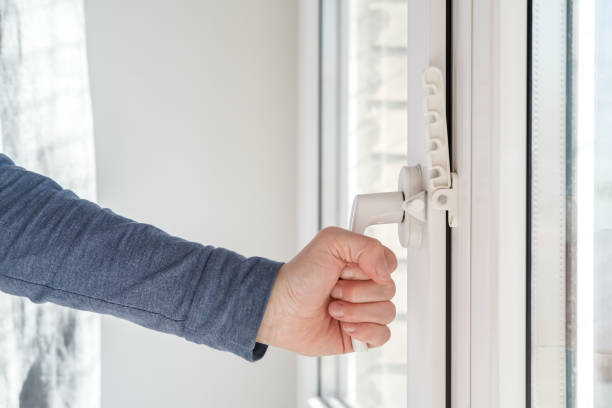 istock Female hand closed a modern white PVC window, with an attached fixing device for ventilation, in natural light. 1327463488