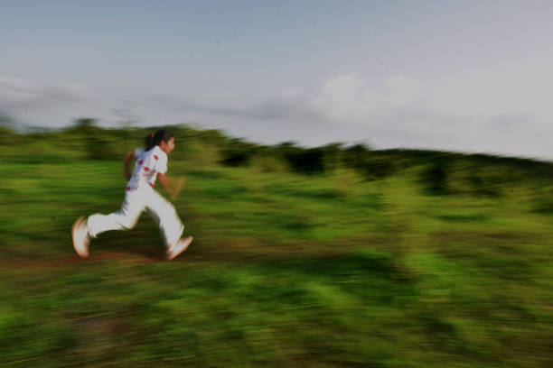 Motion blur picture of a girl running on a footpath over the hills
