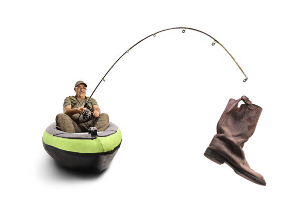 Fisherman sitting in a canoe and holding an old boot on a hook isolated on white background