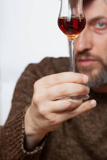 istock Glass with grappa in man hand close up 1327468470