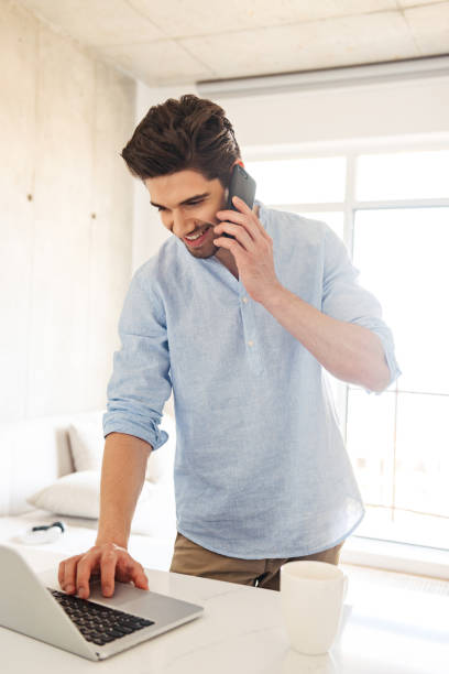 istock Portrait of a smiling young man using laptop computer 1327468773