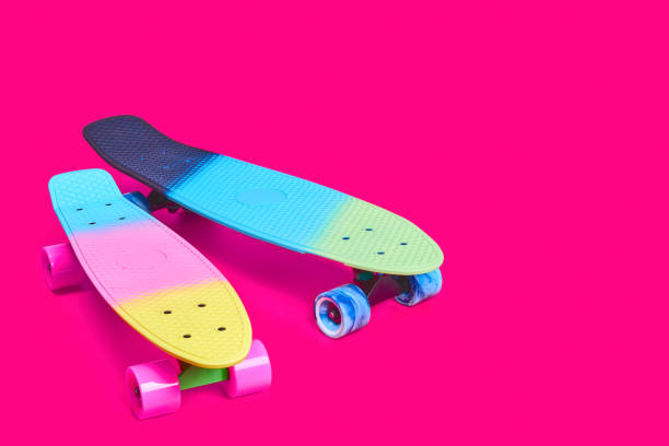 istock Two rainbow plastic Penny board skateboards on crimson background 1327469722