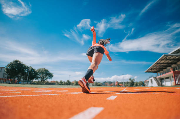 rückansicht aerodynamik asiatische chinesische athletinnen sprinten auf der strecke und rennen morgens im leichtathletikstadion in richtung ziellinie - tartanbahn stock-fotos und bilder