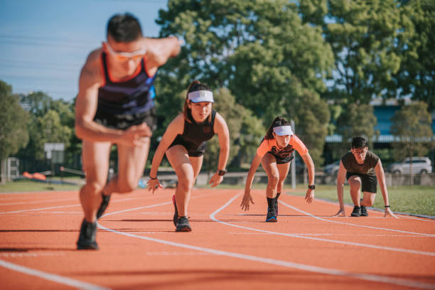 asiatische chinesische junge athleten sprinten auf der strecke und laufen morgens im leichtathletikstadion auf die ziellinie - mixed age stock-fotos und bilder