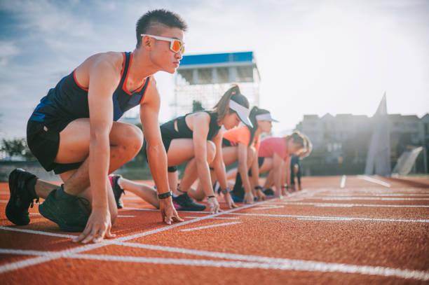 istock Asian chinese athletes lining up getting ready starting line running at track and run towards finishing line in the morning at track and field stadium 1327476859
