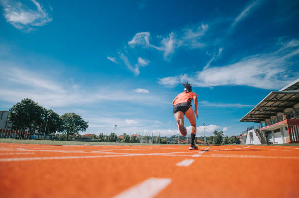 vista trasera aerodinámica atletas asiáticas chinas sprint corriendo en pista y correr hacia la línea de meta por la mañana en el estadio de atletismo - pista de atletismo de tartán fotografías e imágenes de stock