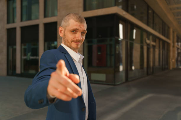 istock A young handsome business man pointing in a camera 1327478852