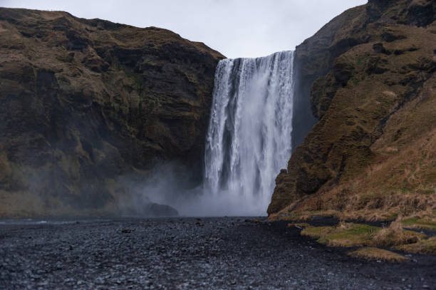 istock Skogafoss Waterfall In Iceland. Long Exposure Water Spray and Rocks. 1327480555