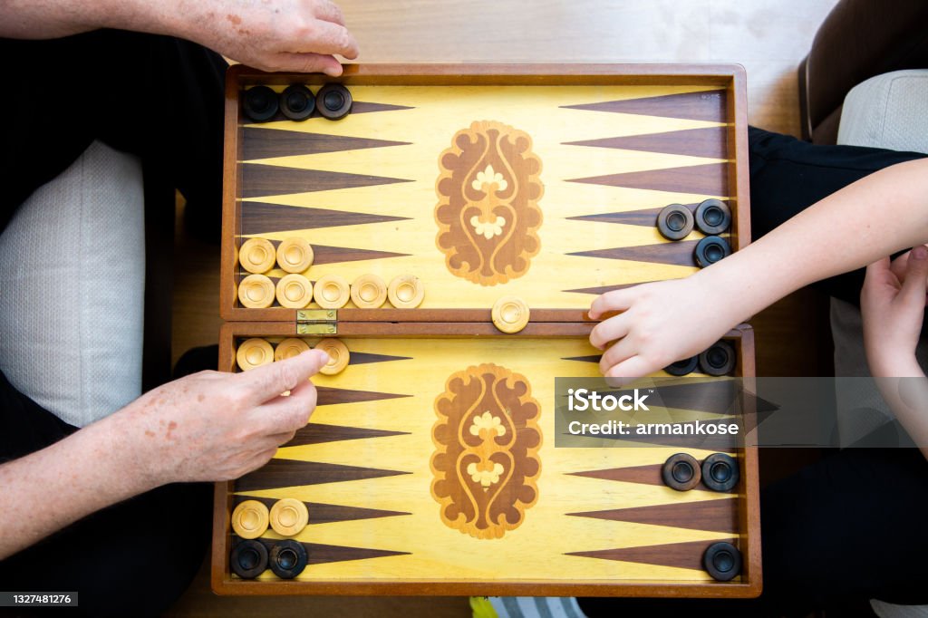 Hands of grandpa and grandson playing backgammon Backgammon Stock Photo
