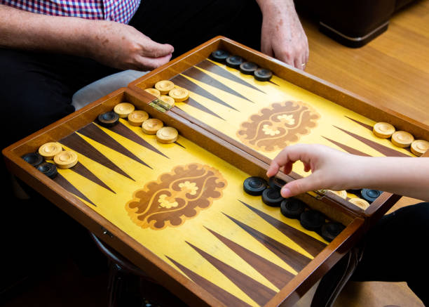 istock Hands of grandpa and grandson playing backgammon 1327481727