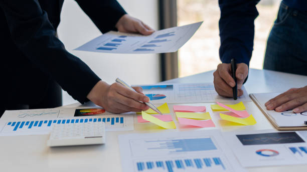 istock Image of business people discussing documents and ideas at a meeting analyzing graphs together. 1327481820