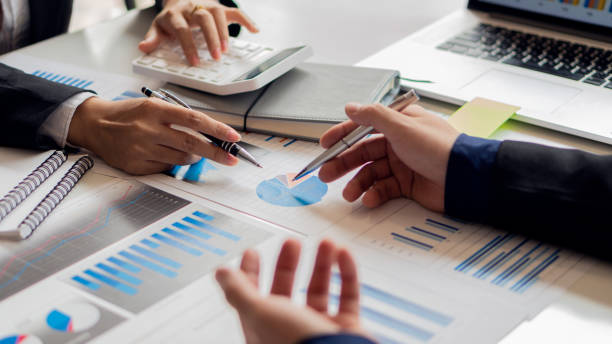 istock Image of business people discussing documents and ideas at a meeting analyzing graphs together. 1327481834