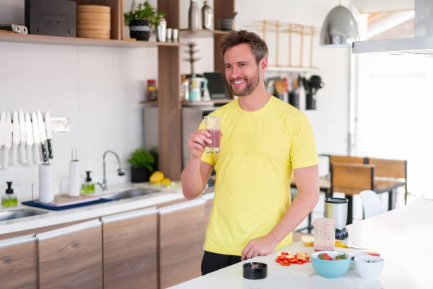 счастливый ч�еловек дома пить здоровый коктейль на завтрак - vegetable smoothie drink multiple exposure стоковые фото и изображения