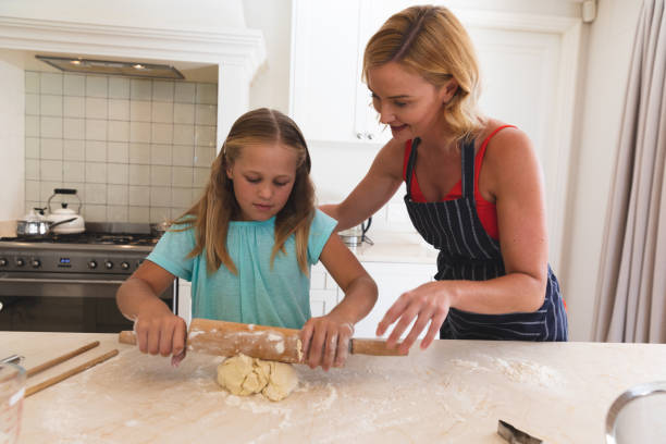 istock Caucasian mother and daughter baking and smiling in kitchen 1327484074