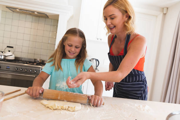 istock Caucasian mother and daughter baking and smiling in kitchen 1327484123