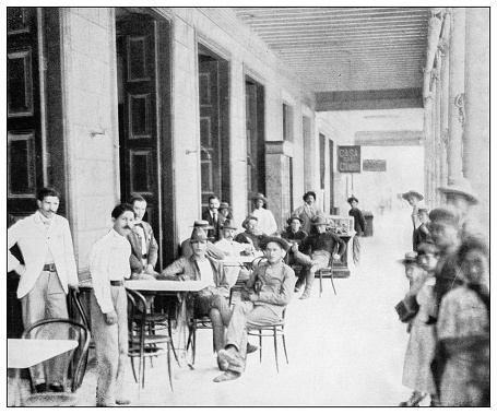 Antique black and white photograph of people from islands in the Caribbean and in the Pacific Ocean; Cuba, Hawaii, Philippines and others: Portico of Matanzas coffee house, Cuba