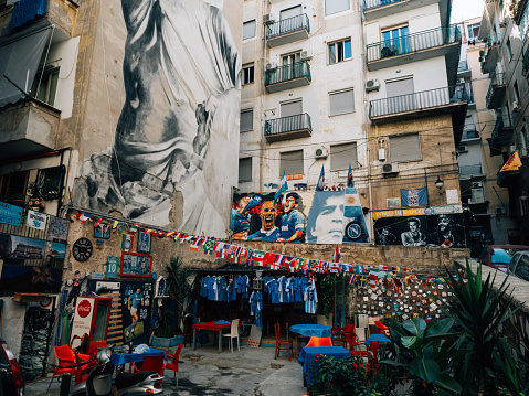 A small market of Naples soccer team uniforms in Quartieri Spagnoli district, Naples. A big graffiti of Statue of Pudicizia on the left.