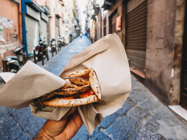 pov vue d’un homme mangeant une « pizza a portafoglio » typique à naples, italie - naples photos et images de collection