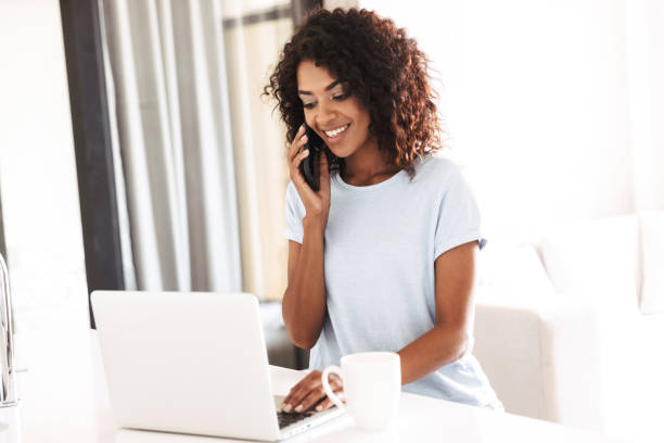 istock Smiling african woman talking on mobile phone 1327493010