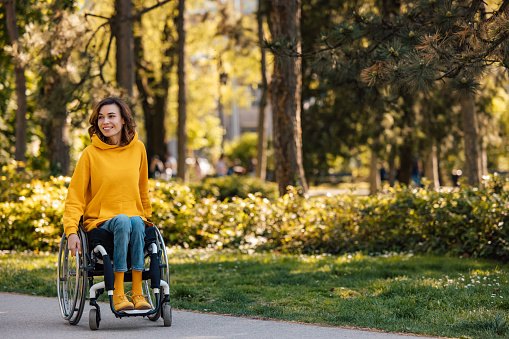 Disabled woman, going to her parents, through the park.