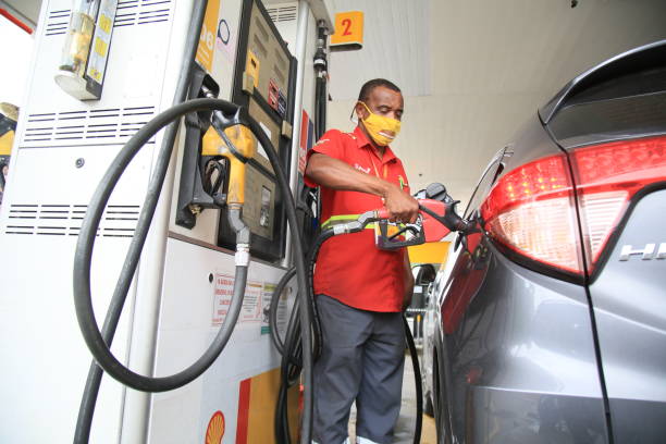 gas station in salvador salvador, bahia, brazil - july 6, 2021: attendant refuels in a vehicle at a gas station in the city of Salvador. butane photos stock pictures, royalty-free photos & images