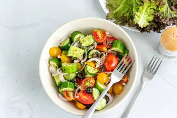 Healthy Tomato, Cucumber, Olive Vegan Salad on White Background