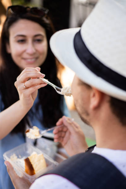 istock Young couple eating strawberry cake outside 1327499510