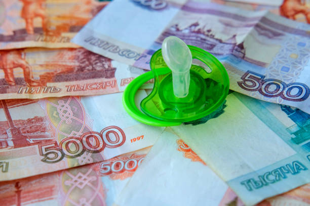 istock Green  pacifier  on Russian money five thousand, five hundred and one thousand rubles. State benefits. Payments from children. 1327500190