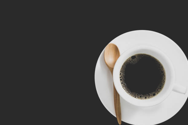 schwarzer kaffee in weißer kaffeetasse und untertasse mit holzlöffel auf schwarzem hintergrund. - 123rf stock-fotos und bilder