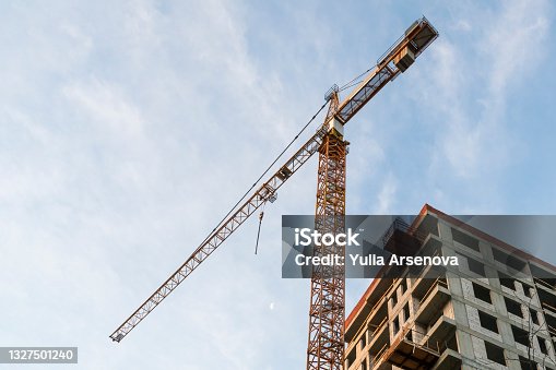istock Building construction site and tower crane against blue sky. Growth concept. Copy space for text. 1327501240