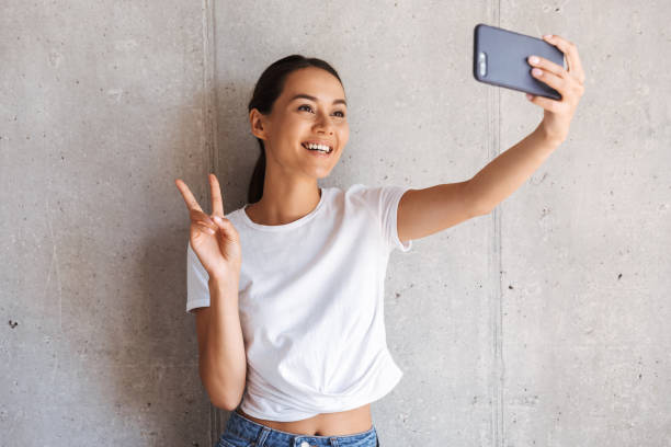 istock Smiling young asian woman taking a selfie 1327501273