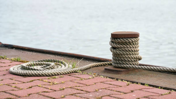 Bollard and mooring rope from a moored ship Bollard and mooring rope from a moored ship on the Mittellandkanal near Magdeburg in Germany mooring line stock pictures, royalty-free photos & images