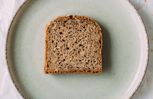 A slice of homemade rye bread on a plate, a close up