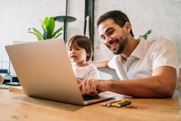 istock A father helping his son with online school at home. 1327505131
