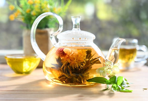 istock Glass teapot with a blooming tea flower 1327513994