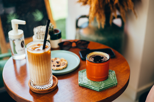 Ice latte americano and a cookie on the coffee table