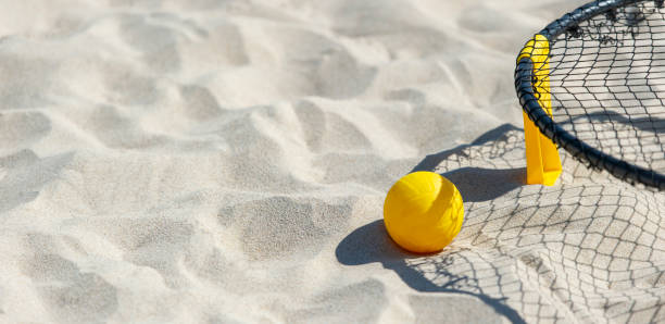 Spike ball game with yellow ball on sand. Summer game concept