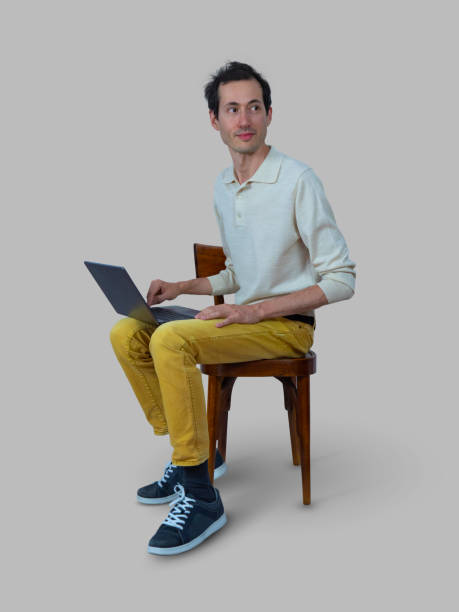 istock Young man sitting on the chair using laptop 1327516626