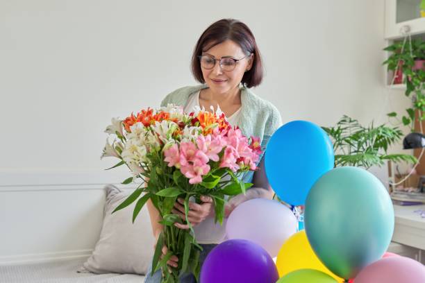 aniversário, 45 anos, feliz mulher com buquê de flores e balões - 40 45 years fotos - fotografias e filmes do acervo