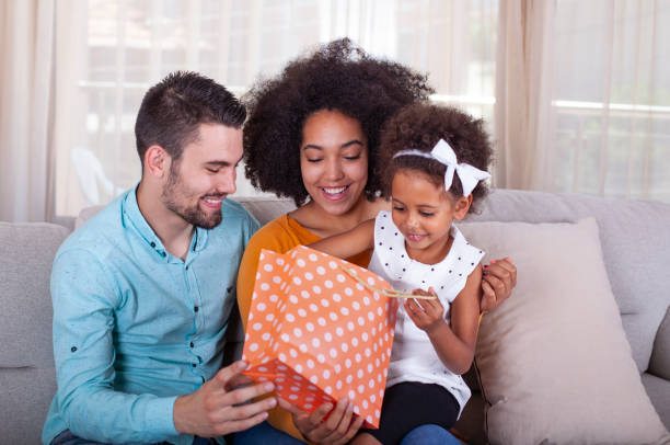 istock Parents giving present to daughter at home 1327518930
