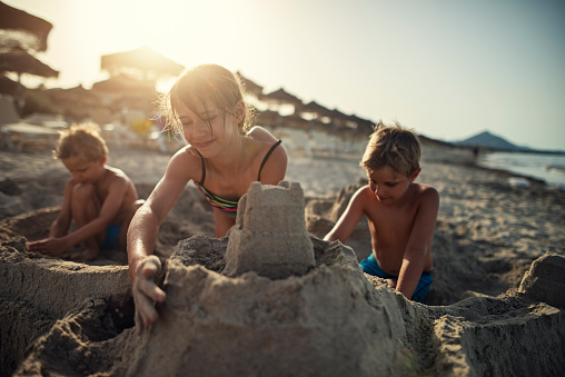 Happy kids are building sandcastle on a beach. Sunny summer evening. Majorca, Spain.
Nikon D800