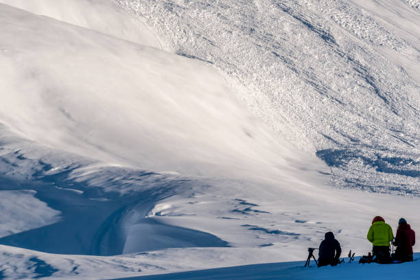 istock Backcountry skiers relax on snowy mountain ridge 1327520611