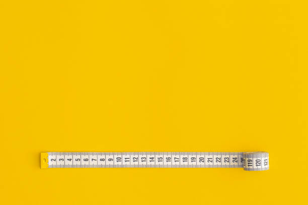 istock Measuring tape on yellow background 1327525852