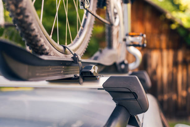 bicicleta instalada en el portabicicletas de techo en un coche de plata, paisaje coutryside en el fondo - bicycle rack fotografías e imágenes de stock