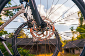 Close-up on a front bicycle wheel, another bicycle in the background