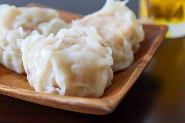 albóndigas de camarones chinos al vapor envueltas en un panqueque de harina fina y agua llamado shaomai. - shumai fotografías e imágenes de stock